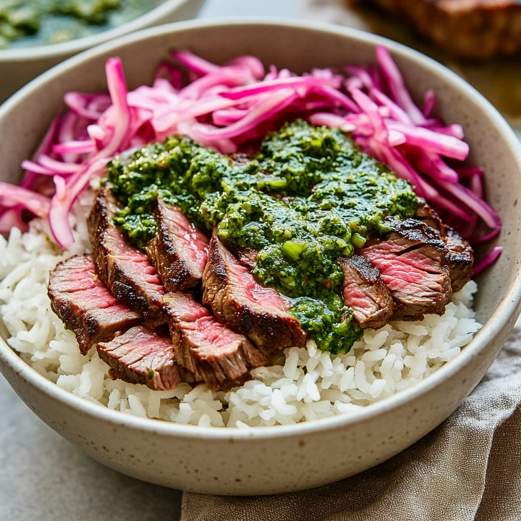 A delicious bowl with skirt steak, rice, chimichurri, and herbs.