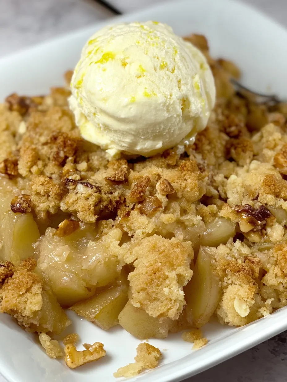 A bowl of apple pie with a scoop of ice cream on top.